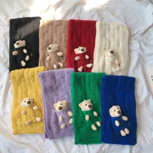 Gros plan détaillé de charmantes écharpes en tricot avec poches ours en peluche colorées.