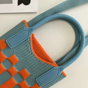 Gros-plan sur le sac bandoulière en tricot bleu et orange, texture de mini sac.