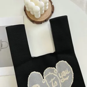 Vue détaillée rapprochée du sac cabas en tricot noir doté d'un joli motif de cœur.