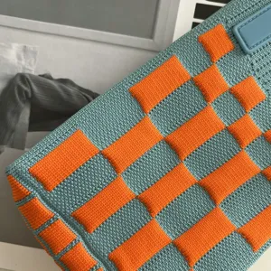 Sac bandoulière mini tricoté avec motif à carreaux bleu et orange, gros plan détaillé.