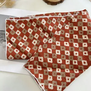 Gros plan détaillé du carré de coton à motif géométrique rétro et imprimé floral.