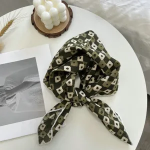Vue détaillée d'un élégant carré en coton vert à fleurs, idéal pour chemises ou foulard.