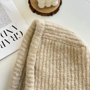 Beiges grobes Strickmützen Detail zeigt dicke Textur und warmes Wollgewebe für den Winter