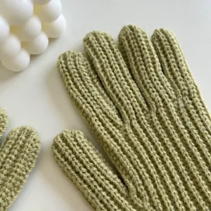 Gedetailleerd overzicht van groene gebreide handschoenen met fijne ribstructuur voor de winter.