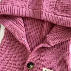 Nahaufnahme der rosa Damen Strickkapuze Schal Haube, warmes Wollmaterial mit süßem Knopf.