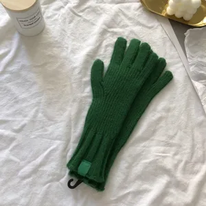 Detail view of women winter warm solid green knitted gloves, cozy everyday cold weather wear.