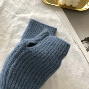 Closeup of cozy blue knitted fingerless gloves, winter warm ribbed arm warmers for women.