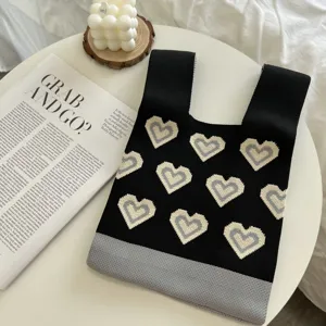 Knit tote bag detail view, black and grey color with cute heart pattern for women daily use.