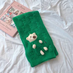 Écharpe d'hiver en tricot torsadé vert avec un joli détail de poupée en peluche, douce et chaude.