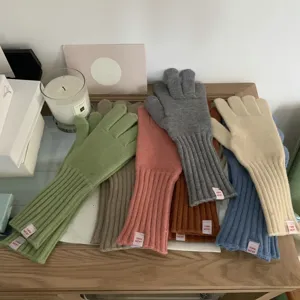 Detailed shot of colorful knit gloves featuring cozy woolen material and cute cuff label designs.