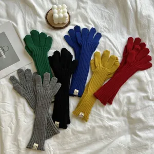 Detail view of women's long knit solid color gloves, cozy winter warm ribbed wrist gloves.