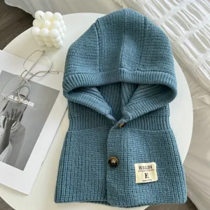 Nahaufnahme des blauen gestrickten Kapuzenschals mit Knöpfen, kuscheliger wärmender Kragen.