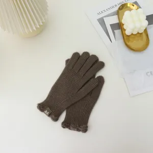 Close-up of brown knit gloves with cute ruffles, cozy winter warm split-finger design.