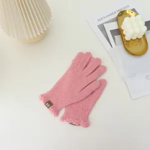 Pink knit touchscreen gloves with cute ruffle trim detail, cozy winter warmth for women and girls.