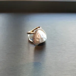 Close-up shot of a chic triangle pearl ring and scarf buckle featuring sparkling crystal pavé details.