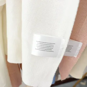 Detailansicht des Strickschal-Stoffs und Pflegeetiketts mit weicher Textur und feiner Verarbeitung.