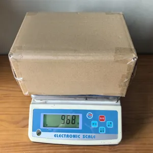 Detailed view showing the package weight of the wooden tissue box on an electronic scale.