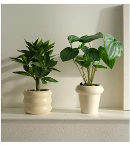 Detail view of artificial potted plants, Nordic style green faux foliage for indoor desktop decor.