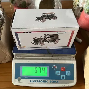 Detailaufnahme der Retro-Vintage-Auto-Modellbox auf elektronischer Waage mit Gewicht, Metall.