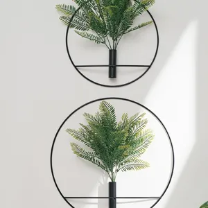 Minimalist metal ring wall hanging planter with artificial green fern leaves for home decor.