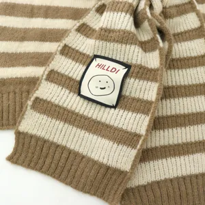 Close-up view of the striped knitted scarf detail, showing soft texture and cozy autumn style.