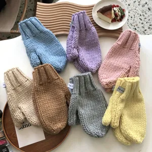 Close-up of colorful chunky knit mittens in various shades, thick winter thermal gloves.