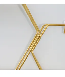 Close-up detail of modern Nordic geometric gold iron wire wall shelf corner and welding.