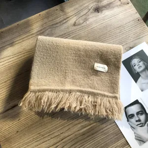 Winter warmer einfarbiger Fransen-Schal im Detail, kuscheliger Stoff mit süßem Etikett.