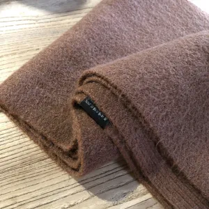 Primer plano del tejido de bufanda de invierno texturizado marrón con material suave.