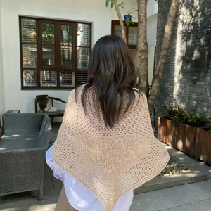 Detailed view of knitted triangle shawl with heart pattern, cozy autumn winter accessory.