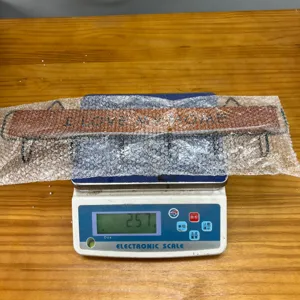 Detailed view of the wooden wall hook rack being weighed on an electronic scale for quality.