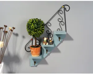 Wall-mounted stair shelf with iron scrollwork and wooden steps, featuring decor details and hooks.