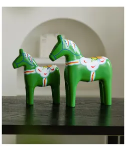 Hand-painted green wooden Dala horse figurine set, exquisite traditional home decor detail.