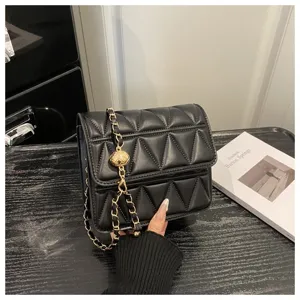 Black quilted shoulder bag with gold chain and metal ball detail, elegant crossbody purse.