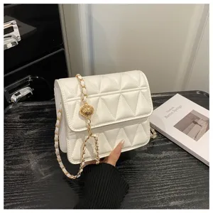Detailed shot of the chic white quilted small square shoulder bag with a gold chain strap.