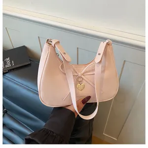 Sac à épaule hobo rose avec nœud et pendentif cœur, sac croissant élégant pour femmes.