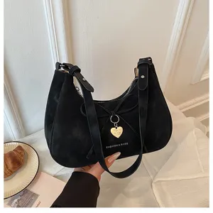 Vue détaillée du sac porté épaule noir avec nœud et pendentif cœur, accessoire mode quotidien.