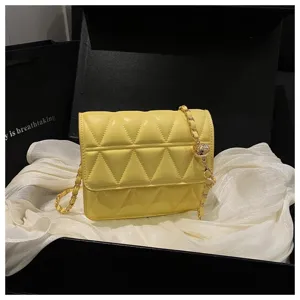 Yellow quilted small square bag detail, featuring stylish chain strap and chic metal ball.