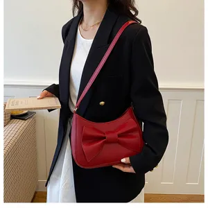 Red leather shoulder bag with a stylish bow detail, perfect for daily fashion and chic commuting.