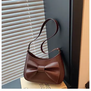 Brown PU leather underarm bag detail showcasing elegant large bow and fine texture.