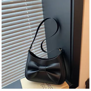 Black shoulder bag with elegant bow detail, stylish underarm design, versatile fashion accessory.