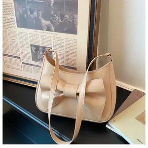Chic beige underarm shoulder bag with a stylish front bow detail, modern minimalist design.