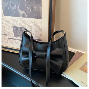 Black leather shoulder bag for women, stylish underarm bag with elegant bow design.