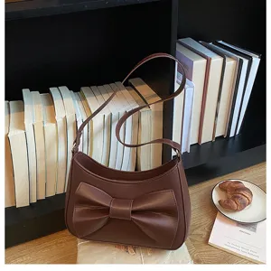 Dark brown leather shoulder bag featuring a stylish front bow detail. Perfect retro aesthetic.