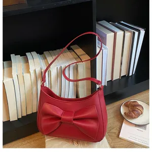 Chic red shoulder bag for women featuring a stylish front bow and sleek underarm design.
