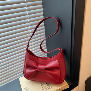 Elegant red shoulder bag for women featuring a chic bow design. Perfect stylish underarm purse.