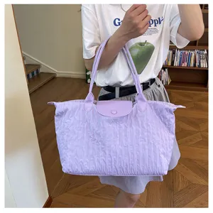 Detailed view of the light purple nylon shoulder tote bag featuring dual handles and snap flap.