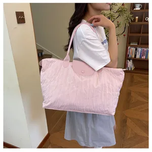 Detail view of the pink quilted shoulder tote bag worn by a model, showing daily style.