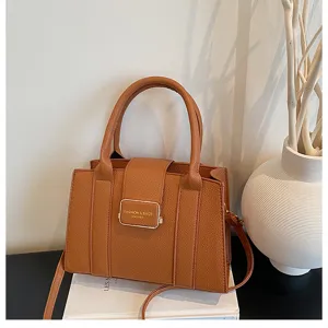 Gros plan du sac a main en cuir PU marron avec fermoir metallique et finition texturee.