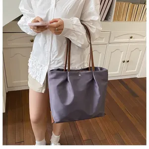 Detail shot of purple oxford cloth tote shoulder bag with brown handles for women daily commute use.